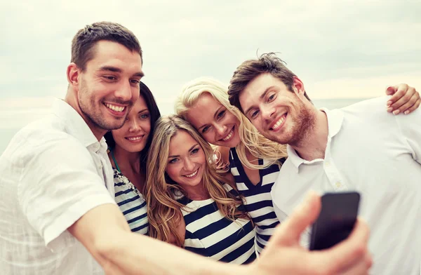 Happy friends on beach and taking selfie — Stock Photo, Image