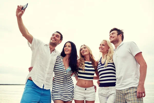 Amigos felices en la playa y tomar selfie — Foto de Stock