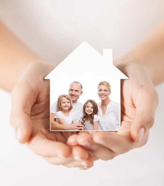 Primer plano de las manos sosteniendo la forma de la casa con la familia —  Fotos de Stock