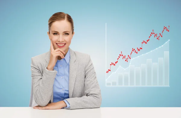 Femme d'affaires souriante assise à table avec graphique — Photo