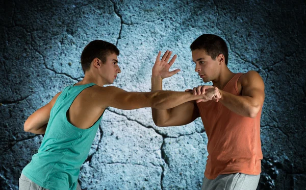 Junge Männer kämpfen Hand in Hand — Stockfoto