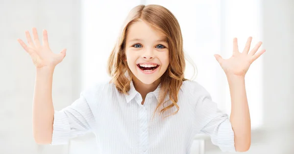 Surprised and laughing girl with raised hands — Stock Photo, Image