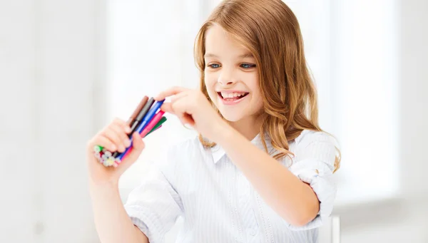 Uśmiechnięta dziewczyna wybiera kolorowy Flamaster — Zdjęcie stockowe