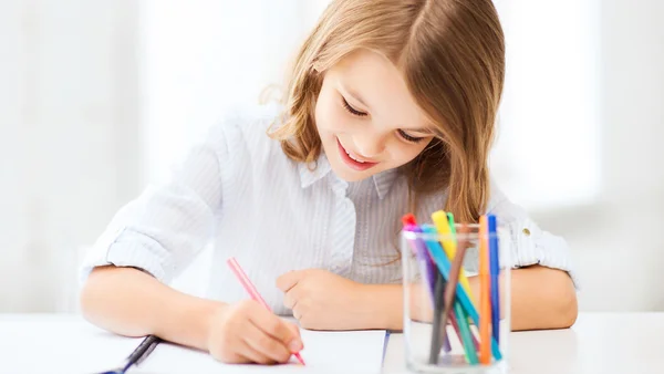 Kleine Schülerin zeichnet in der Schule — Stockfoto