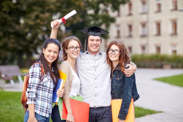 Happy teenage students with diploma and folders — Stock Photo, Image