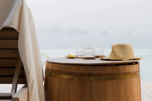 Vasos de agua con sombrero en barril en la playa del hotel — Foto de Stock