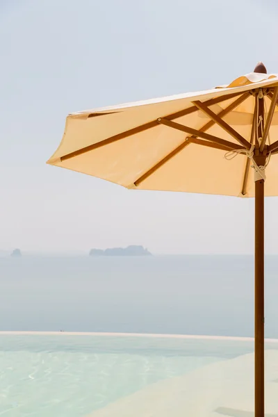 Vista dalla piscina a sfioro con ombrellone al mare — Foto Stock