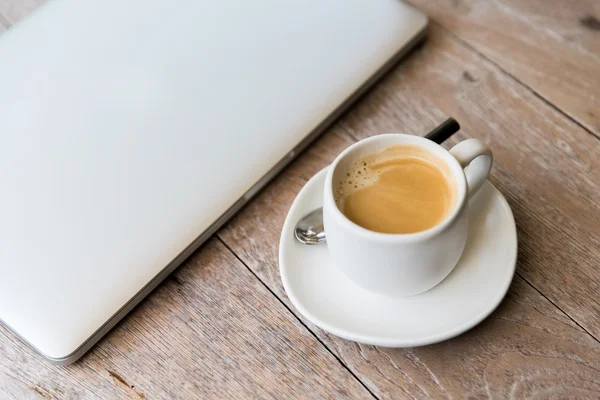 Primo piano del computer portatile e della tazza di caffè sul tavolo dell'ufficio — Foto Stock