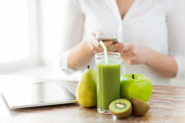 Close up of woman with smartphone and fruits — Stock Photo, Image