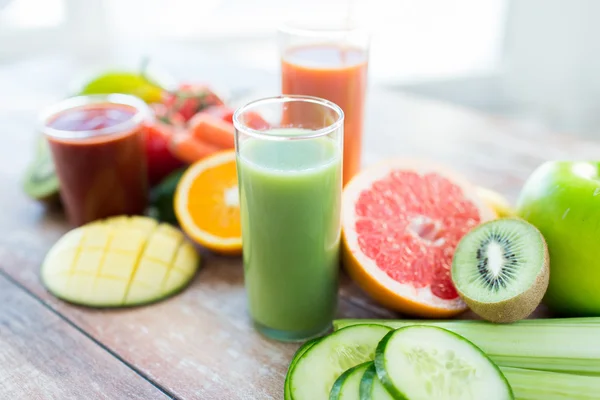 Närbild av färsk juice glas och frukter på bord — Stockfoto