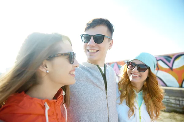 Happy teenage friends in shades talking on street — Stock Photo, Image