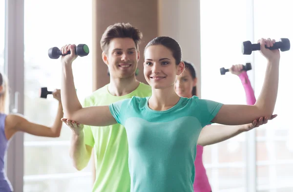 Glada kvinnor och tränare med hantlar i gym — Stockfoto