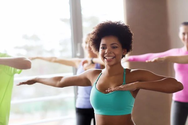 Group of smiling people dancing in gym or studio — Stock Photo, Image