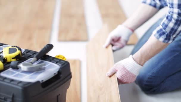 Primo piano dell'uomo l'installazione di pavimenti in legno — Video Stock