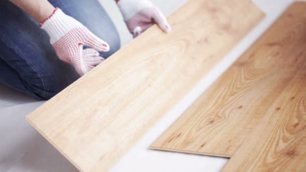 Close up of man installing wood floor — стоковое видео