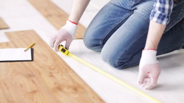 Close up of man measuring flooring and writing — Stock Video