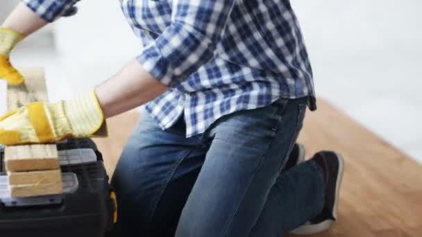 Close up of man hammering nail to wooden board — Stock Video