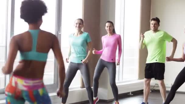 Groupe de personnes souriantes dansant en salle de gym ou studio — Video