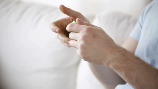 Primer plano del hombre jugando juego en el teléfono inteligente en casa — Vídeos de Stock