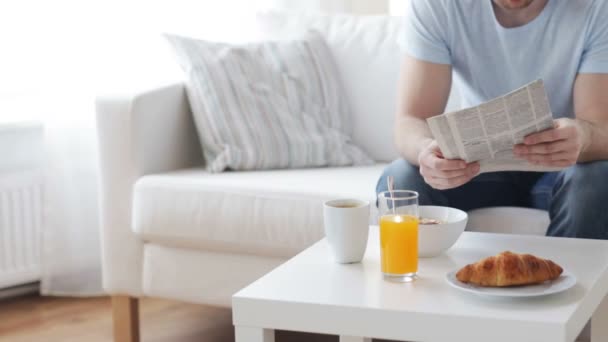 Närbild på mannen med tidningen med frukost — Stockvideo