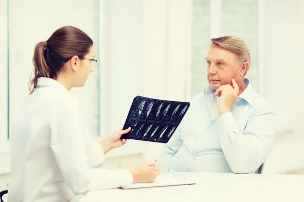 Vrouwelijke arts met oude man kijken naar x-ray — Stockfoto