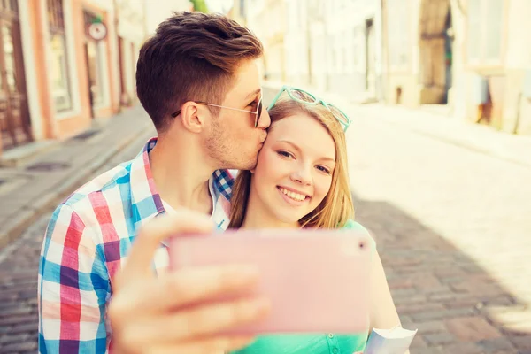 Pareja sonriente con smartphone en la ciudad — Foto de Stock