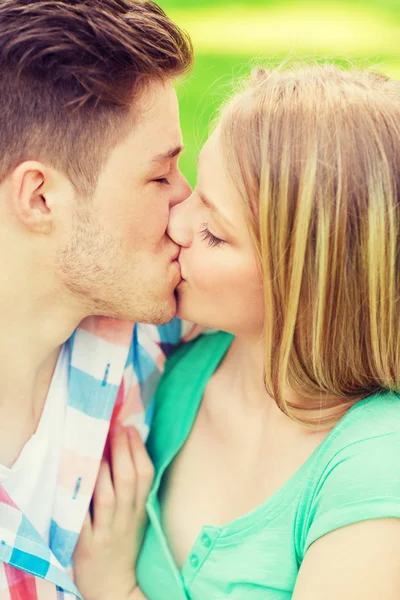 Sorridente coppia baci e abbracci nel parco — Foto Stock