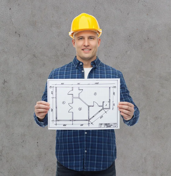 Sorridente construtor masculino no capacete com planta — Fotografia de Stock