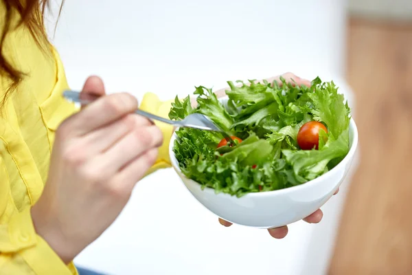 Primer plano de la mujer joven comiendo ensalada en casa —  Fotos de Stock