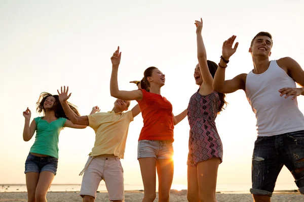 Amigos sonrientes bailando en la playa de verano —  Fotos de Stock