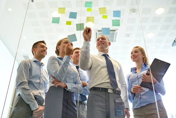 Smiling business people with marker and stickers — Stock Photo, Image