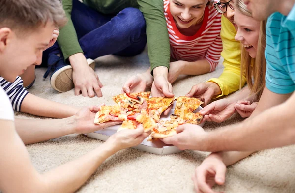 Close up of happy friends eating pizza at home — Stock Photo, Image