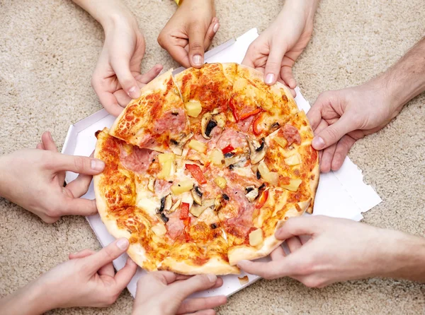 Detailní záběr happy přátel jíst pizzu doma — Stock fotografie