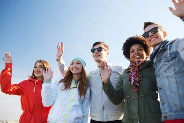 Heureux adolescents amis dans les nuances agitant les mains — Photo