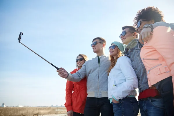 Amigos sonrientes tomando selfie con teléfono inteligente —  Fotos de Stock