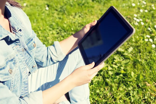 Primer plano de la chica con la tableta de la PC sentado en la hierba — Foto de Stock