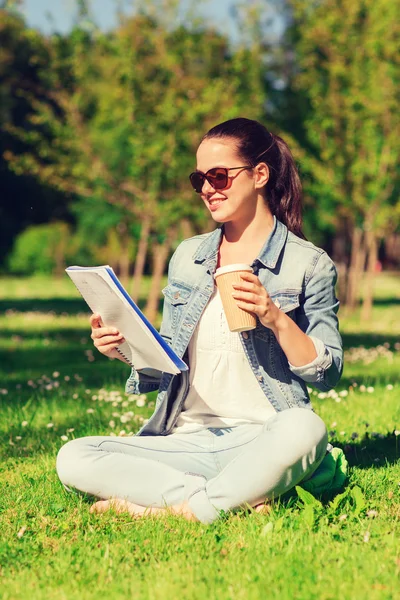 Niña sonriente con portátil y taza de café — Foto de Stock