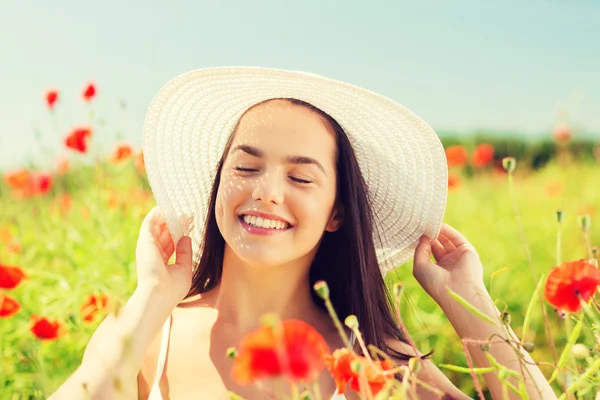 Jeune femme souriante en chapeau de paille sur champ de pavot — Photo