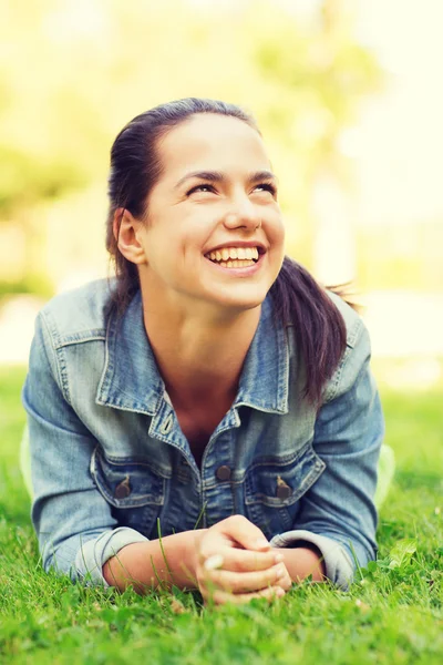 Uśmiechnięta młoda dziewczyna leżąc na trawie — Zdjęcie stockowe