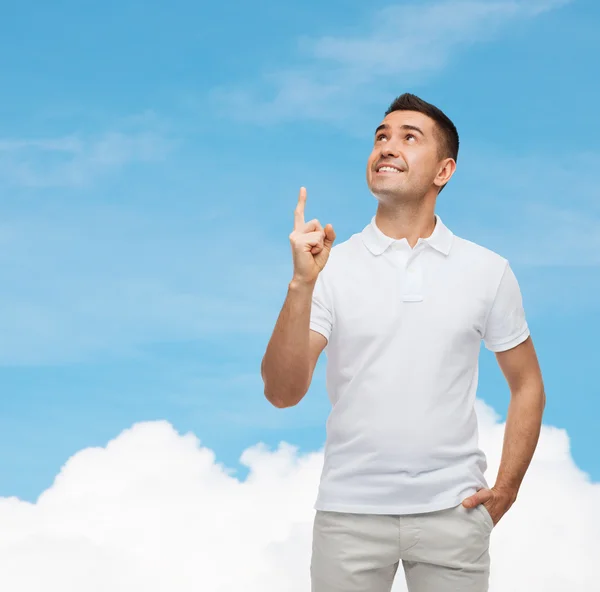 Homme souriant pointant le doigt vers le haut sur le ciel bleu — Photo