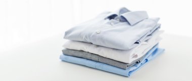 close up of ironed and folded shirts on table clipart