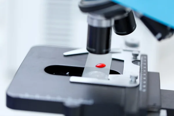 Bliska próbki krwi i mikroskopu w laboratorium — Zdjęcie stockowe