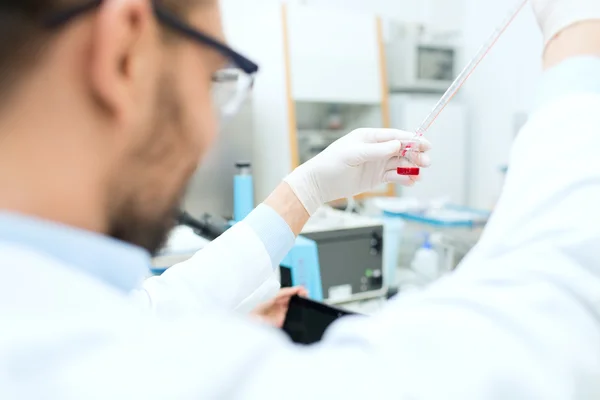 Nahaufnahme eines Wissenschaftlers mit Tubus und Pipette im Labor — Stockfoto
