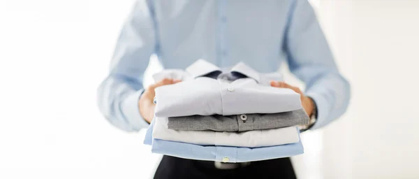 Primer plano de hombre de negocios sosteniendo camisas dobladas — Foto de Stock