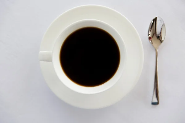 杯黑咖啡，勺子和桌上的碟 — 图库照片