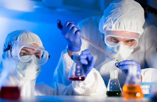 Perto de cientistas que fazem testes em laboratório — Fotografia de Stock