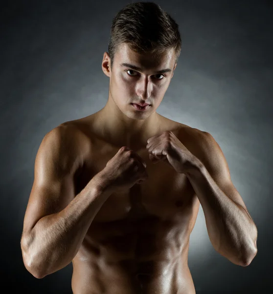 Jeune homme sur le stand de combat sur fond noir — Photo