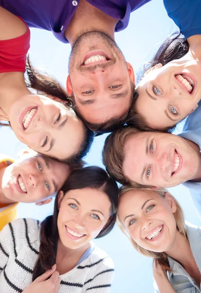 Smiling friends in circle on summer beach Royalty Free Stock Images