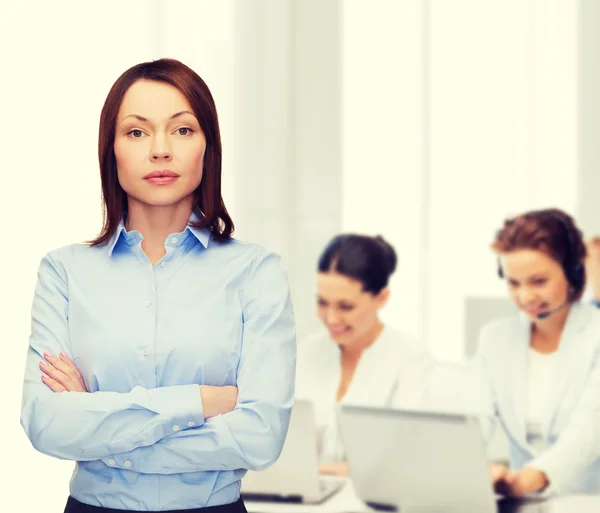 Lächelnde Geschäftsfrau mit verschränkten Armen im Büro — Stockfoto