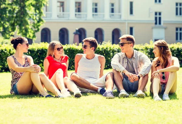 Gülümseyen arkadaş açık havada çimde oturma grubu — Stok fotoğraf